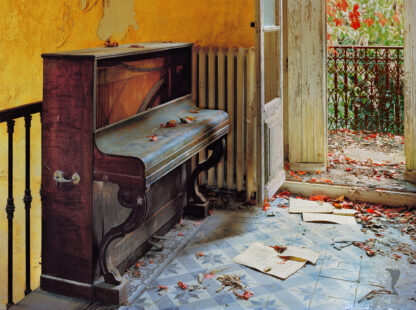 Das Foto ist im Spätherbst entstanden. Es zeigt eine offene Balkontür. Rote Blätter vermischen sich auf dem alten Steinfußboden mit Notenblätter, die von einem Klavier, welches links neben der Tür steht heruntergefallen sind.